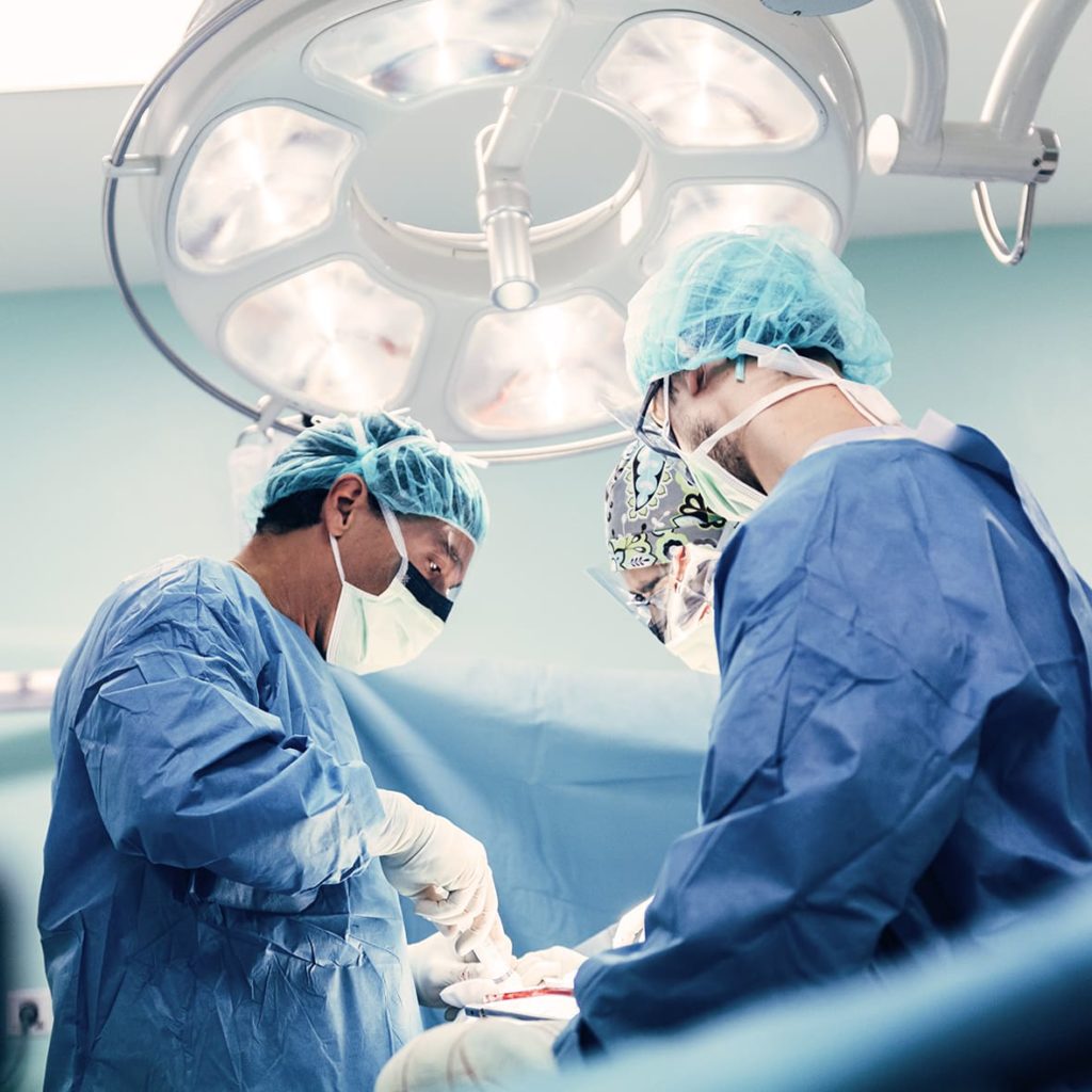 Surgeons in operating room performing operation.